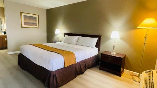 a bedroom with a large bed and two lamps at Rodeway Inn Jackson in Jackson