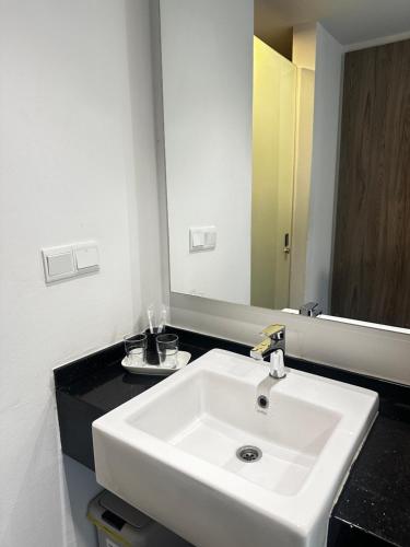 a bathroom with a white sink and a mirror at Nasai Retreat Studio in H Elite Design Building in Kota Bharu