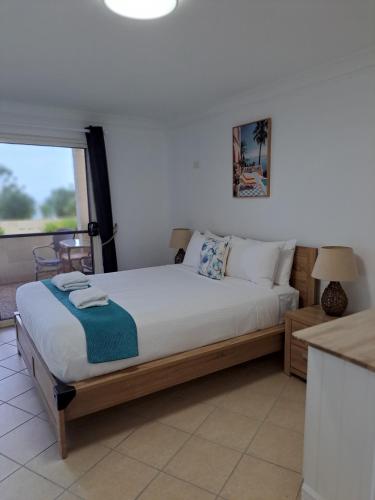 a bedroom with a bed and a large window at Villa Mar Colina in Yeppoon