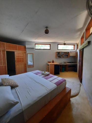 een slaapkamer met een groot bed en twee ramen bij Casa kuxtal in Zipolite
