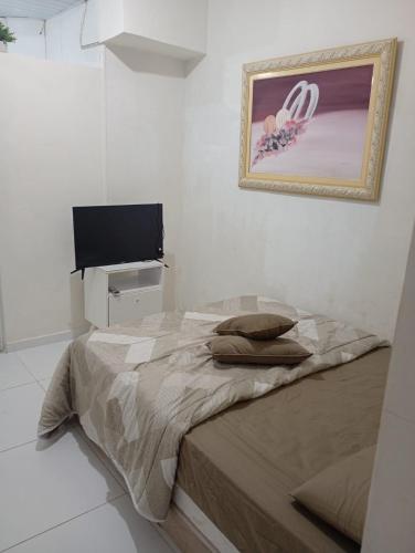 een slaapkamer met een bed en een flatscreen-tv bij Marreal in Arraial do Cabo