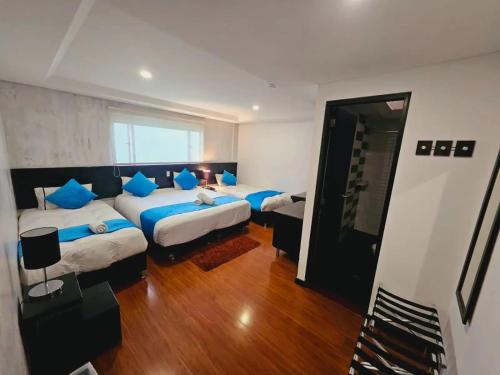 ein Schlafzimmer mit zwei Betten mit blauen Kissen in der Unterkunft Hotel Classic in Bogotá