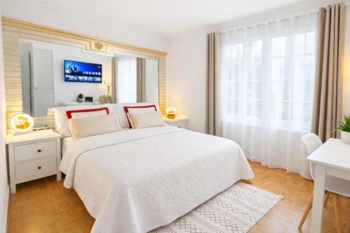 een witte slaapkamer met een groot bed en een raam bij Appartement F1 F2 in Drancy