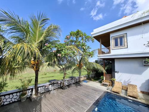 a villa with a swimming pool and a house at suffers villa medewi in Medewi