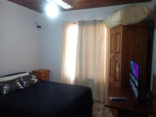 una camera da letto con un letto, un comò e una finestra di Lilemar a Miramar