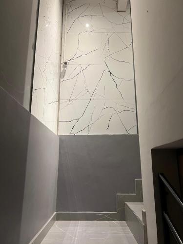 a bathroom with a shower with a marble wall at San Juliano Studios in Foz do Iguaçu