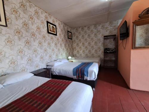a hotel room with two beds and a tv at Casona Cruz Verde in Arequipa