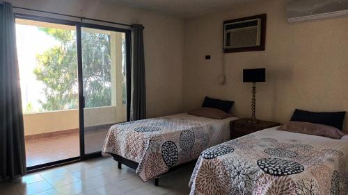 维多利亚城Residencia completa 2 recamaras para 4 con cochera的一间卧室，配有两张床和一个大窗户