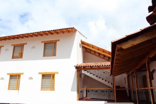 a white building with wooden balconies in front of it at Hotel Cacique Real in Zipaquirá