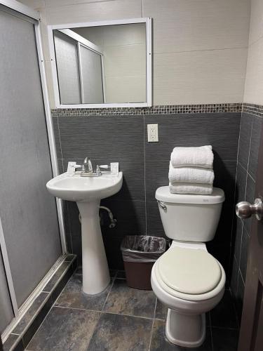 a bathroom with a toilet and a sink and a mirror at Hotel Presidente Tijuana in Tijuana