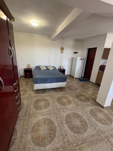 ein Schlafzimmer mit einem Bett und einem Kühlschrank in einem Zimmer in der Unterkunft Único loft con pileta cerca de Villa Carlos Paz in San Antonio de Arredondo