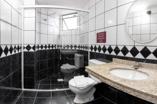 un bagno con un water, un lavandino e uno specchio di Hotel Beach Canasvieiras a Florianópolis