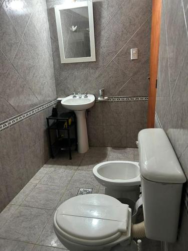 a bathroom with a toilet and a sink at Alquiler temporal Colonia Caroya in Colonia Caroya