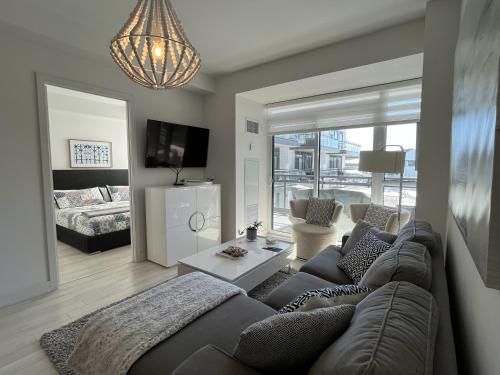 een woonkamer met een bank en een woonkamer met een televisie bij Stunning Stayz Luxury 2 King Suite at Friday Harbour Resort Marina Walk & Parking in Innisfil