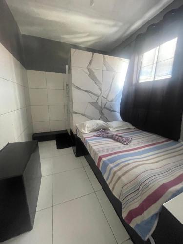 een klein bed in een kamer met een raam bij Hotel saffire in Feira de Santana