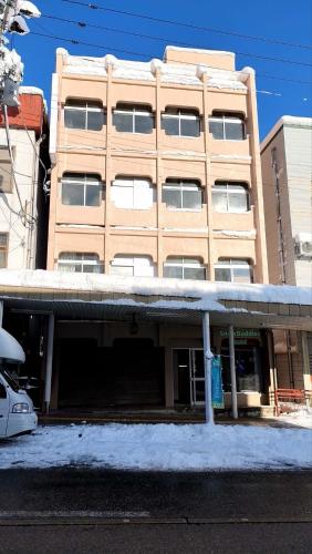 a tall building with snow in front of it at 湯沢粉雪の宿 in Yuzawa