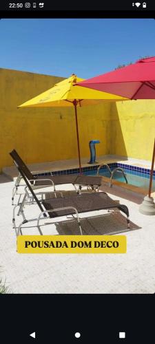a group of chairs and an umbrella next to a pool at Casa da Piscina in Maceió