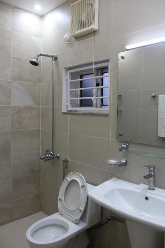 een badkamer met een toilet, een wastafel en een spiegel bij Legacy Guest House in Islamabad
