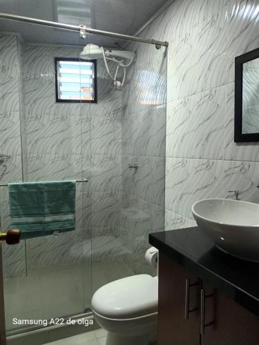 a bathroom with a toilet and a sink and a shower at Casa punta del este in Paipa