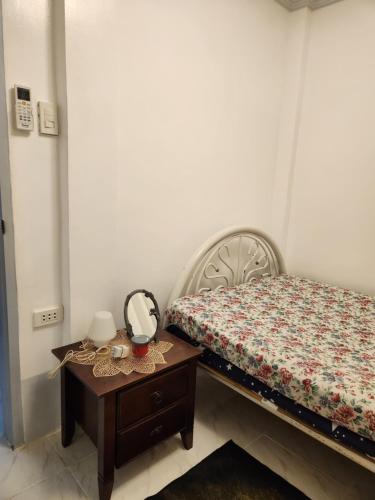 a small bedroom with a bed and a table at Teachers Home in Panong