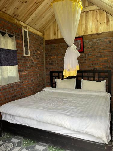 a bed in a room with a brick wall at Chi Homestay in Sapa