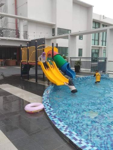 ein Schwimmbad mit Rutsche in einem Gebäude in der Unterkunft Mikayla Suite in Kota Bharu