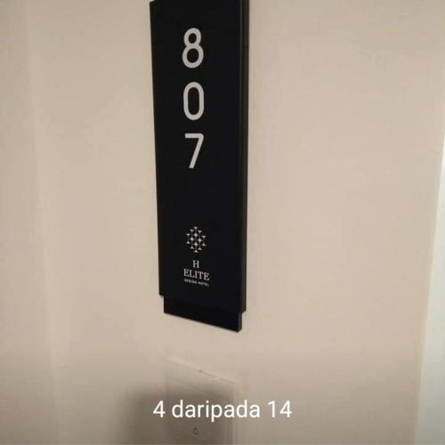eine schwarze Fernbedienung, die an einer weißen Wand hängt in der Unterkunft Mikayla Suite in Kota Bharu