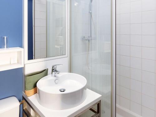 ein weißes Badezimmer mit Waschbecken und Dusche in der Unterkunft greet hotel Lille Gare Flandres - Groupe Accor in Lille