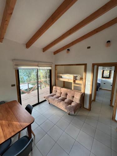 ein Wohnzimmer mit Sofa und Tisch in der Unterkunft Cabaña Los Arrayanes 2 in Coihueco