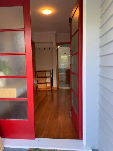 a red door leading into a room with a hallway at The River Bothy in Christchurch