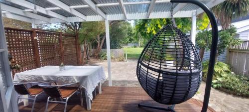 a patio with a table and a bird cage at The River Bothy in Christchurch