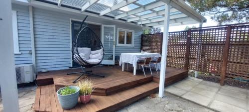 a patio with a table and an umbrella on a deck at The River Bothy in Christchurch