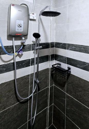 a shower in a bathroom with black and white stripes at Grand Luxury Hotel Semporna in Semporna