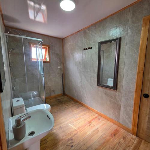 a bathroom with a sink and a shower and a mirror at Cabaña 1 - Rancho Doble AA in La Junta