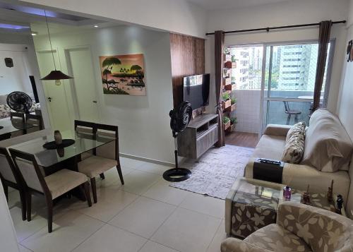 een woonkamer met een bank, een tafel en een televisie bij Morada Pio IX in Recife
