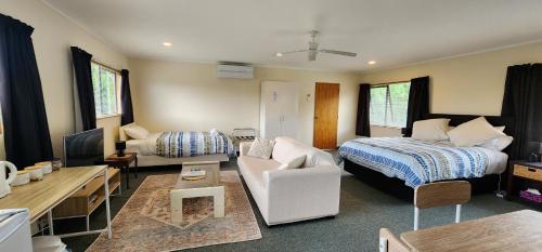 une chambre avec un lit et un salon dans l'établissement Avocado Orchard Retreat!, à Katikati