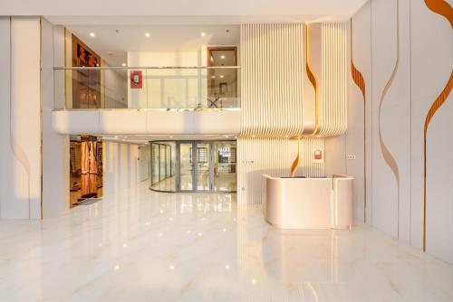a lobby with a white floor and a staircase at Grand Lux by BRIO in Danang