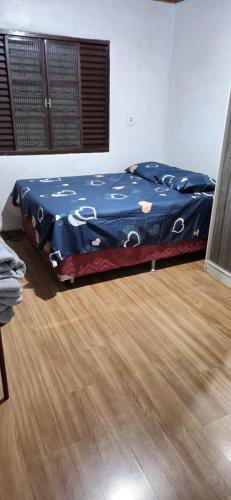 a bed in a room with a wooden floor at Casa do Fernando in São Gabriel