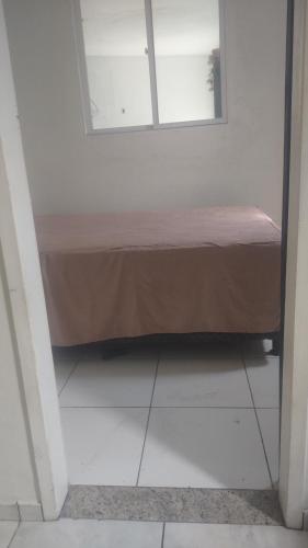 een klein bed in een kamer met een raam bij Espaço em Pero hospedagem in Cabo Frio