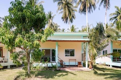 une maison avec des palmiers devant dans l'établissement Green Heaven Bungalows, à Nathon Bay