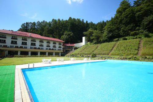 a large swimming pool in front of a hotel at Nozawa Grand Hotel in Nozawa Onsen