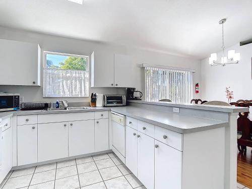 eine weiße Küche mit weißen Schränken und einem Fenster in der Unterkunft Gulf Coast Home 3BR2BA for 8 in North Port