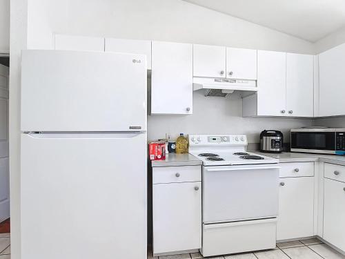 eine Küche mit weißen Schränken und einem weißen Kühlschrank in der Unterkunft Gulf Coast Home 3BR2BA for 8 in North Port