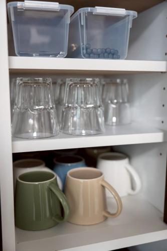 a white refrigerator filled with cups and utensils at PREMIUM O2stay citrus onomichi in Onomichi