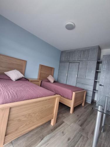 two beds in a room with wooden floors at Cielito Lindo in Uruapan del Progreso