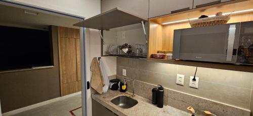 een keuken met een spoelbak en een tv aan de muur bij Beach Class Verano Muro Alto in Porto De Galinhas