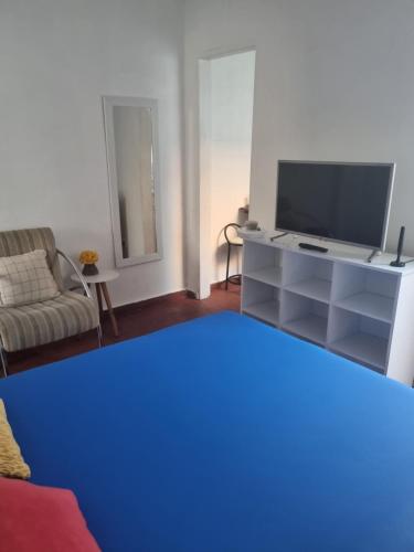 een woonkamer met een tv en een bank bij Casa da Bisa Ubatuba in Ubatuba