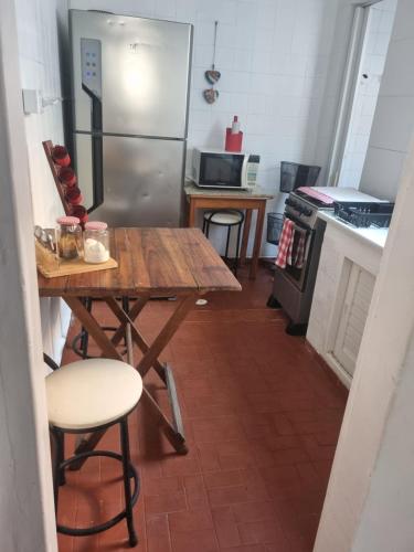 een keuken met een houten tafel en een koelkast bij Casa da Bisa Ubatuba in Ubatuba