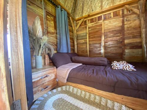 ein Schlafzimmer in einer Holzhütte mit einem Bett in der Unterkunft Batur Twin house in Kubupenlokan