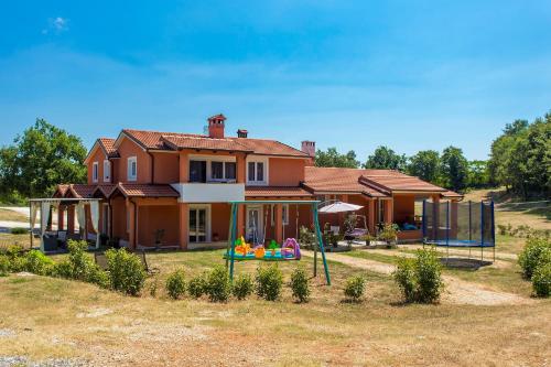 a house with a playground in front of it at Apartments Matelici in Divšići